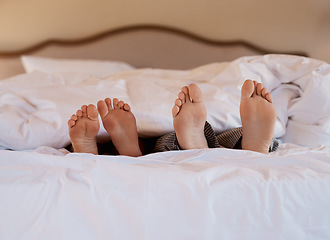 Image showing I belong next to you. Shot of an unrecognizable couples feet poking out under the sheets while lying in bed.