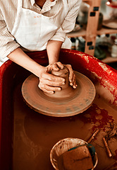 Image showing Clay is one of the easiest mediums to work with. Cropped shot of an unrecognizable woman molding clay on a pottery wheel.