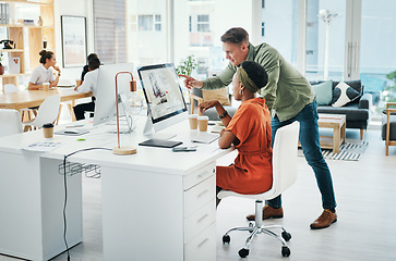 Image showing I think this one looks great. Full length shot of two young business colleagues working on a computer together in the office.