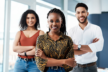 Image showing The future of this business rests with us. Cropped portrait of an attractive young businesswoman standing with her arms crossed in front of her colleagues in the office.