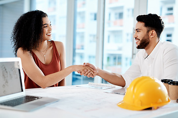 Image showing I cant wait to see how it turns out. Cropped shot of two young businesspeople sitting together and shaking hands in agreement with building renovation plans.