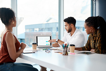 Image showing We did very well as a company here. Cropped shot of a handsome young businessman using his laptop during a meeting with his female colleagues in the office.