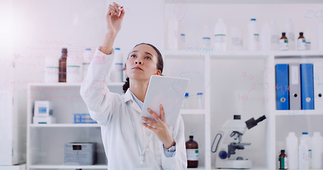 Image showing Science is about answering many questions. Shot of a young scientist writing notes on a glass wall in a lab.