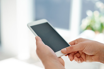 Image showing Modern business requires modern technology. Cropped shot of an unrecognizable businesswoman using her smartphone inside of an office.