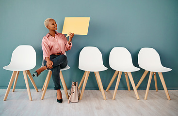 Image showing Thats lovely news. Studio shot of an attractive young businesswoman holding up a speech bubble while siting in line against a grey background.