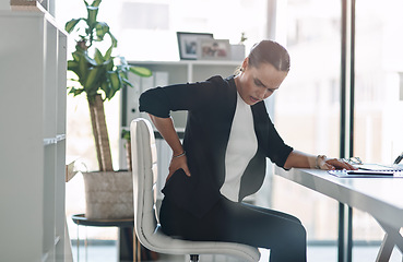 Image showing These long hours are starting to negatively affect her health. Cropped shot of an attractive young businesswoman suffering from back pain while working inside her office.