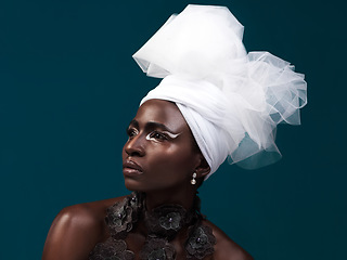 Image showing 100 true beauty. Studio shot of an attractive young woman posing in traditional African attire against a blue background.