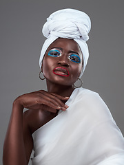 Image showing Striking African beauty. Studio portrait of an attractive young woman posing in traditional African attire against a grey background.