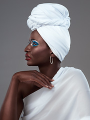 Image showing The simplest accessories speak the loudest. Studio shot of an attractive young woman posing in traditional African attire against a grey background.