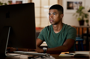 Image showing Stay focused and watch the results come in. Shot of a young businessman using a computer in a modern office.