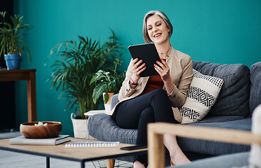 Image showing The business seems to be doing well. Cropped shot of an attractive mature businesswoman sitting alone and using a tablet in her home office.