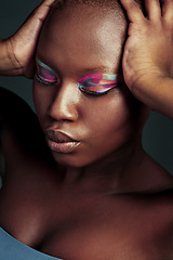 Image showing Why fit in when you were born to stand out. Cropped shot of a beautiful woman wearing colorful eyeshadow while posing against a grey background.