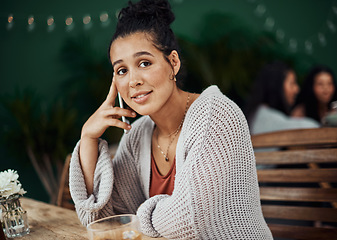 Image showing What time will you be here. Shot of a beautiful young woman using a smartphone at a cafe.