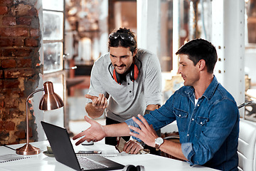 Image showing Thats what weve been considering all along. Cropped shot of two young businessmen working together on a laptop in an office inside their workshop.