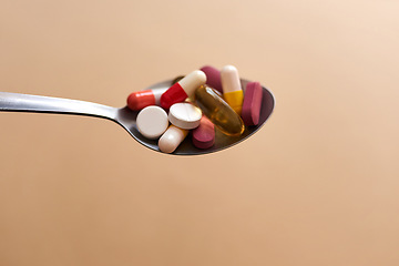 Image showing When a diet turns into an eating disorder. Studio shot of medication served in a spoon against a brown background.