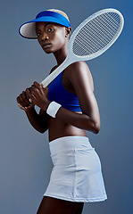 Image showing Want to play against me. Studio shot of a sporty young woman posing with a tennis racket against a grey background.