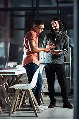 Image showing Hes giving me some really cool ideas. Shot of two businessmen discussing in a notebook while working late.