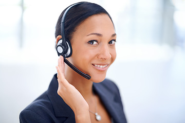 Image showing Service with a smile. An attractive call centre operator smiling at the camera.