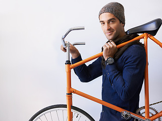 Image showing Like my wheels. Cropped portrait of a trendy young man carrying his bicycle indoors.