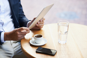 Image showing Online from anywhere he goes. Cropped view of a businessman using his digital tablet in a cafe while he waits.