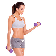 Image showing Staying toned and feeling great. A beautiful young woman working out with dumbbells.