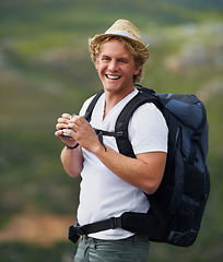 Image showing The view from up here is sublime. Shot of a young man with binoculars hiking outdoors.