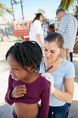 Image showing We all need access to medical care. Shot of a volunteer nurse examining a young patient with a stethoscope at a charity event.