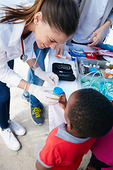 Image showing Donating her time and medical expertise to her community. Shot of a volunteer doctor giving checkups to underprivileged kids.