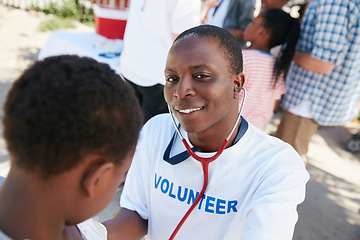 Image showing On a mission to provide great medical care. Shot of a volunteer doctor examining a young patient with a stethoscope at a charity event.