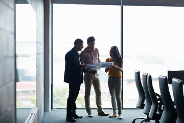 Image showing Sorting themselves out before the meeting. Full length shot of three businesspeople talking in the boardroom.