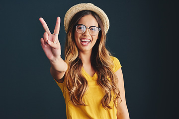 Image showing Im all about peace and love. Studio shot of an attractive young woman against a dark background.