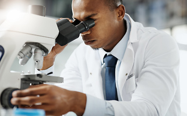 Image showing Looking closer...Cropped portrait of a handsome young male scientist using a microscope while doing research in his lab.