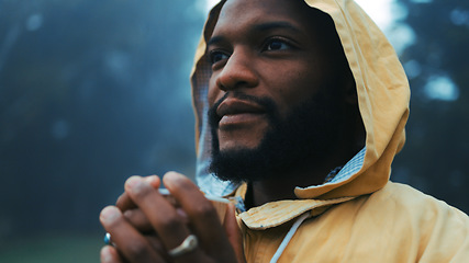 Image showing Coffee, morning and a black man hiking in nature with a blurred background of cold, winter weather. Thinking, raincoat and face with a young male hiker in the woods or forest to explore for adventure