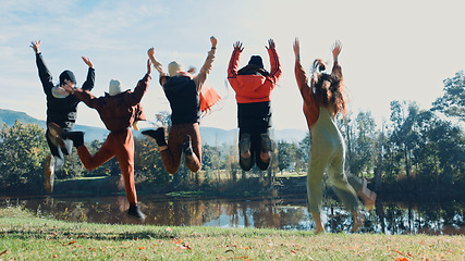 Image showing Friends, jump and camping are happy on adventure with water for fun in nature on weekend. Travel, group and freedom at campsite on holiday with hug at park with lake in environment for vacation.