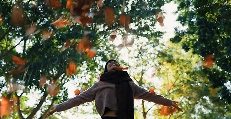 Image showing Woman, autumn and throwing leaves outdoor in a park with trees, freedom and fun in nature. Happy and excited person in warm clothes while playful on an adventure, travel or holiday in fall season