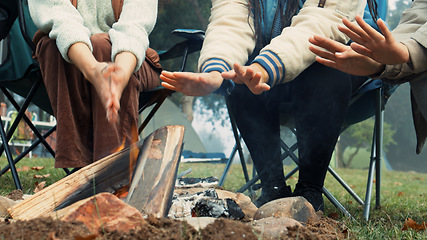 Image showing Wood, fire and warm hands on camping, trip or adventure in nature, forest or friends together at a bonfire in winter. Campfire, smoke and group relax on outdoor vacation, holiday or warming hand