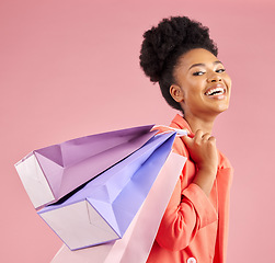 Image showing African woman, studio portrait and shopping bag with discount, sale or excited smile by pink background. Young gen z girl, promotion and happy for deal, retail customer experience or fashion for gift