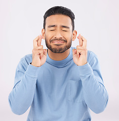 Image showing Fingers crossed, hope and asian man in studio with good luck sign for bonus, prize or giveaway on grey background. Eyes closed, wish and Japanese male with emoji for waiting, reward or lotto results