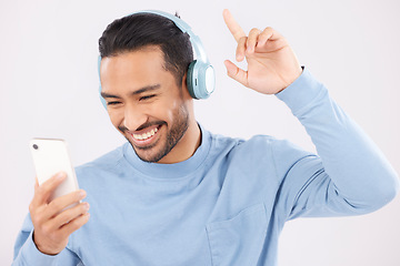 Image showing Headphones, phone and man dancing in a studio with music, album or playlist with technology. Happy, smile and Indian young male person doing a dance to song or radio isolated by a white background.