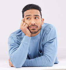 Image showing Thinking, remember and young man in a studio resting on his arms with a contemplating facial expression. Happy, smile and Indian male model with question or dreaming face isolated by white background