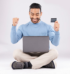 Image showing Celebration, laptop and asian man with credit card in studio excited for cashback bonus on grey background. Online shopping, giveaway and male customer with good news, membership or sign up success