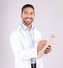 Image showing Portrait, smile and happy man doctor with checklist in studio for medical, compliance or insurance on grey background. Healthcare, form and face of male health expert checking paperwork or agenda