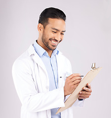 Image showing Writing, smile and happy man doctor with checklist in studio for medical, compliance or insurance on grey background. Healthcare, form and male health expert check paperwork or agenda schedule notes