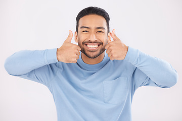 Image showing Portrait, thumbs up and man in studio happy with hand, sign and thank you on white background. Smile, face and Mexican person with emoji for yes, vote or positive review, like feedback or agree