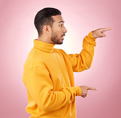 Image showing Man, presentation and pointing to surprise, information and announcement, list and university schedule. Steps, advice and shocked student or young person with hand guide on a studio pink background