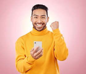 Image showing Winner portrait, man and phone for success, yes and celebration of news, social media or gaming results. Excited, mobile games and person with notification or website bonus on studio, pink background