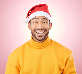 Image showing Portrait, surprise and happy man with Christmas hat, fun and festive for holiday on pink background. Happiness, shock and excited model with smile, santa cap and winter vacation fashion in studio.