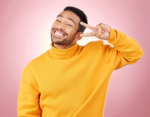 Image showing Happy, peace sign and portrait of man in studio for support, kindness and emoji. Smile, happiness and thank you with face of person on pink background for mindfulness, vote and v hand gesture