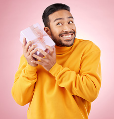 Image showing Man, winner and gift box, birthday celebration and prize, excited giveaway or shopping on pink background. Happy person thinking of present, ribbon package and retail sale or competition in studio