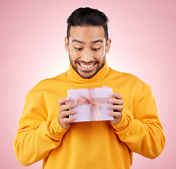 Image showing Man, winner and excited for gift box, prize and giveaway celebration or birthday surprise on pink background. Happy person with present, package and retail shopping or competition success in studio